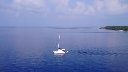 蓝色海洋和干净的沙质背景下的海岸海滩度假无人机空中视频