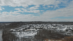 无人驾驶飞机的录像飞越小镇附近树木覆盖着积雪屋顶房屋27秒视频