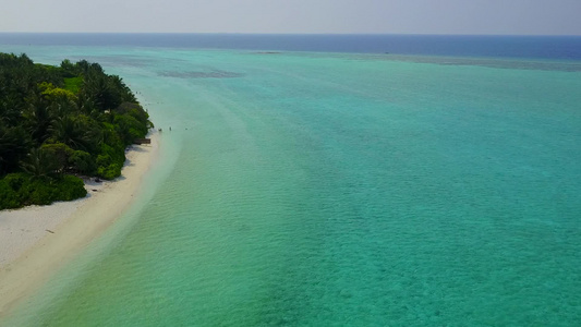 通过蓝海和白沙背景观察宁静的环礁湖海滩时间的海景视频