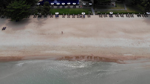 海滩上有许多配对的遮阳休息者在荒凉海滩上用雨伞和干净17秒视频