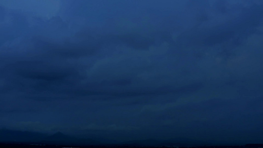 黑暗夜空有乌云飘动穿过绿色的顶峰1视频