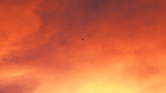 飞机正以日落云的橙红色在天空中飞翔视频