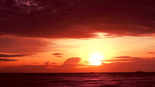 红日落橙色天空和暗红云在海上飘扬视频