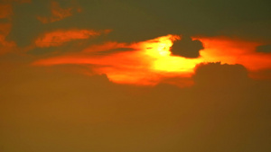 红云下日落时移动通过和橙色天空背景56秒视频