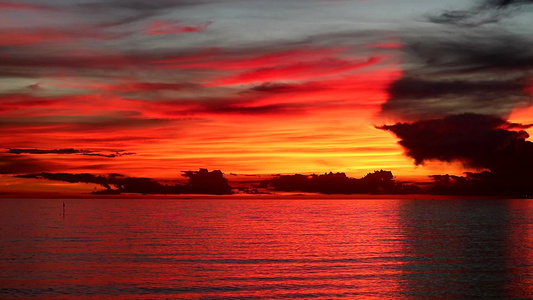 橙色天空的红火日落和海上的黑红月光云视频
