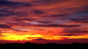 日落橙黄色天空和暗红云在模糊的双周山上飘动15秒视频