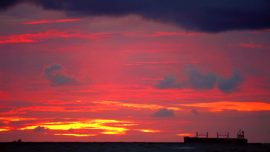 日落橙黄色天空和暗红云在海上轮光船和渔船上飘动视频