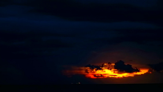 夜空中的乌云和海上的轻型货船在黑暗的暴风雨中落日的视频
