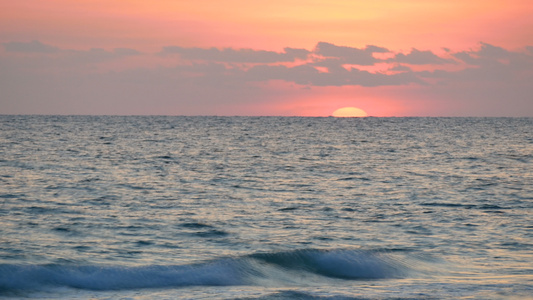4k热带沙滩海面上高山的美丽日落视频