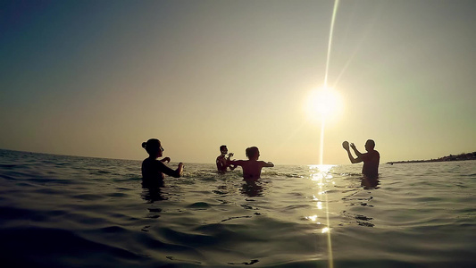 幸福家庭在海洋中玩耍和日落时溅水的剪影—游客在热带视频