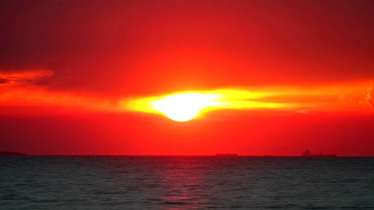 海上的日落时间圈和驶往海港的货船视频