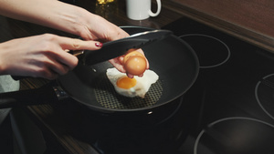 女性用刀把鸡蛋打碎在锅上煎炸16秒视频