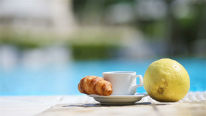 美味的早餐柠檬咖啡羊角面包在游泳池旁边20秒视频