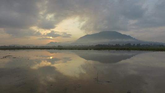 水稻田中美丽的日出风景与反射的BukitMertajam视频