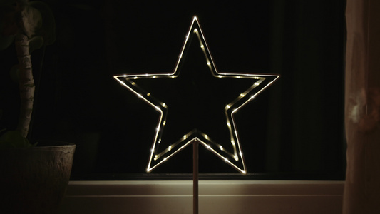 圣诞恒星的灯光装饰闪耀着窗中的反光视频