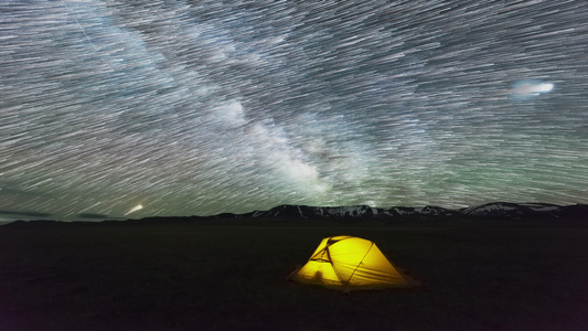 夜星空与黄色发光帐篷上的星迹相伴的星际星空视频