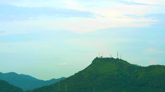 蓝色天空云朵移动穿过绿色的顶峰山烟雾漂浮视频