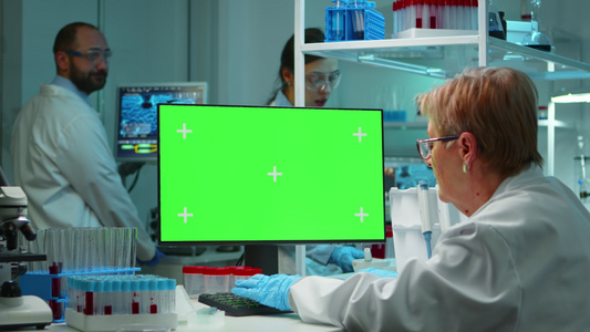 使用绿色屏幕的计算机工作的高级高级医生视频