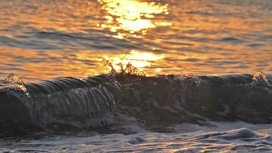 日落缓慢运动时沙滩海浪喷洒宏视频