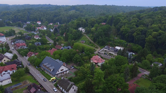 城市建筑和绿林的空中飞行录像视频