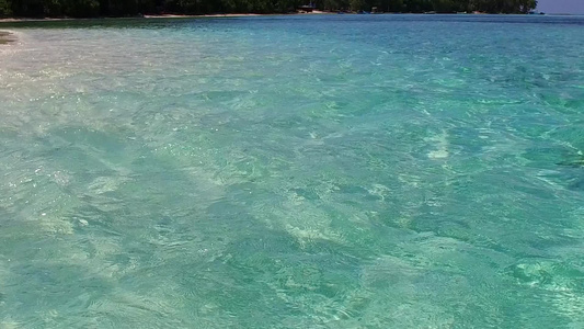 冲浪附近白色沙滩背景的水蓝色海水完美岛屿海滩之旅的视频