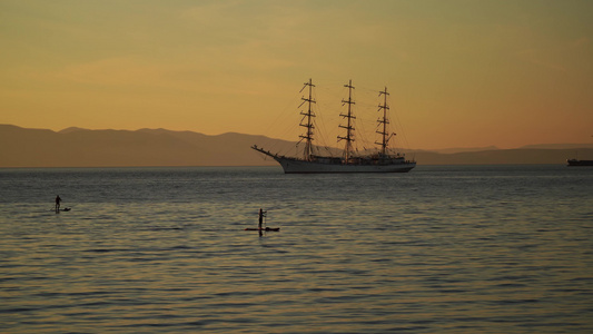 海景有帆船和在板上的人在日落的背景视频