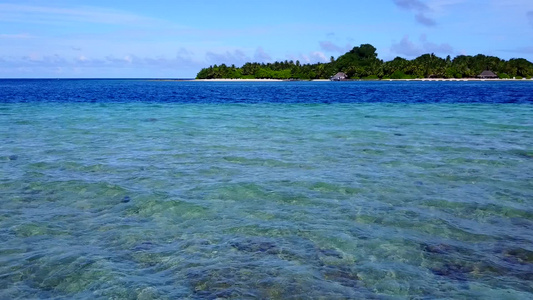 度假村附近水蓝色泻湖和白色沙滩背景的美丽泻湖海滩航行视频