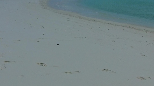 阳光下白沙背景蓝海田园诗般的海滨海滩度假的温暖全景视频