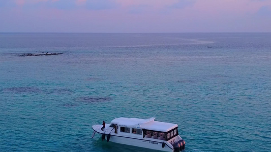 阳光明媚的海景日出后有白色沙子背景的松绿水完美的海岸线视频