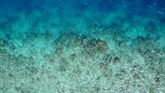 度假村附近白沙背景的蓝海热带旅游海滩之旅的阳光风光视频