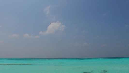 日落前通过蓝海和白沙底的热带环礁湖海滩航行的宽角旅游视频