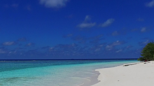 在礁石附近的蓝海和白沙背景下近距离欣赏完美的海岸海滩视频