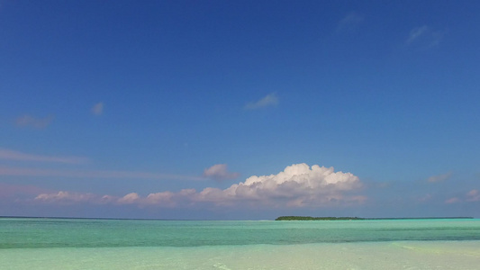 沙滩附近透明的海洋和白色沙沙底背景的阳光明媚的环礁视频