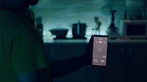 男性在厨房里使用照明控制应用程序13秒视频