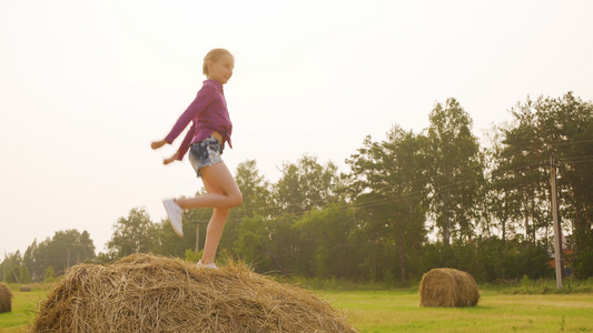 快乐的女孩在干草堆上跳舞视频