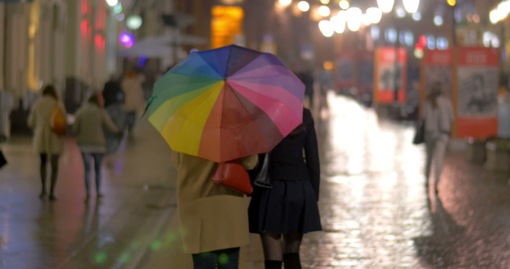 在雨天之夜城市在多彩的雨伞下行走视频