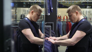 青年男子在商场选择和试穿夹克10秒视频