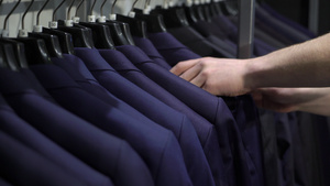 购物和时装概念青年男子在商场选择和试穿夹克9秒视频