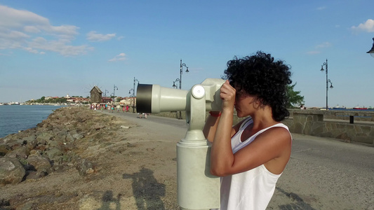 旅游妇女用硬币望远镜在布尔加里亚的旧城市内塞巴使用视频
