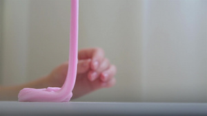 坐在白桌边玩粉色黏液和游戏15秒视频