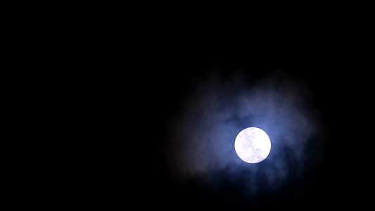 夜空中的黑月在寒冷的天空中回到柔软和黑暗的云层上移动视频