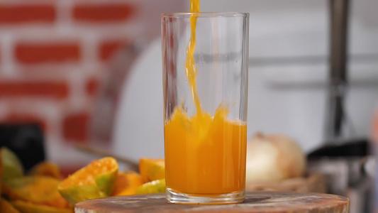 将橙汁倒到厨房的剪切板上一个清澈的玻璃杯里视频