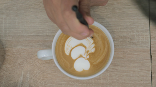 桌子上是一杯咖啡加泡沫的咖啡杯男子则抽取泡沫模式视频