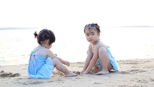 夏日夕阳下儿童在海边沙滩上玩沙子视频