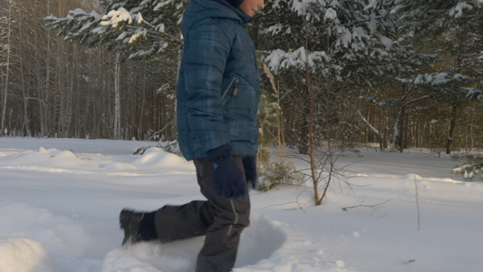 白人男孩走在雪上漂流的冬季公园露天露天视频