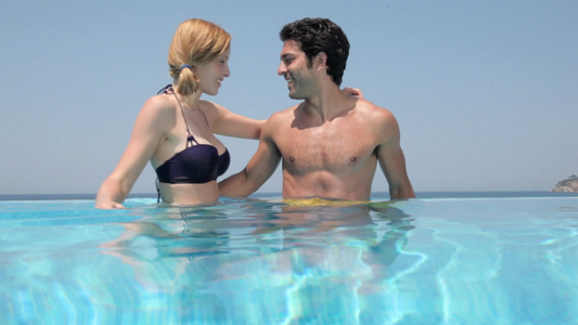 年轻夫妇在无边泳池中亲吻和拥抱视频