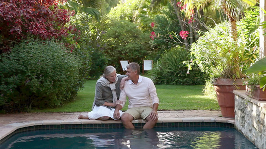 一对夫妇坐在花园的池畔视频