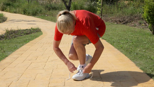 女人跑步和停下来系鞋带的低剖面图11秒视频