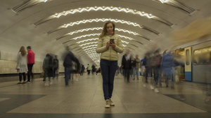 妇女站立在地下地铁站并使用移动电话的时间间隔人群聚集8秒视频