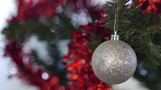 白种人的手在人造树上挂着闪亮的银白色圣诞树球一个年轻视频